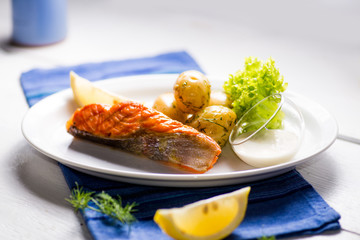 piece of grilled salmon served with vegetables