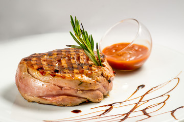 steak, grilled with a sauce. Serving on a white plate