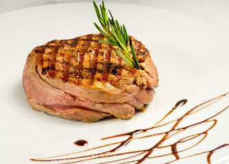 steak, grilled with a sauce. Serving on a white plate