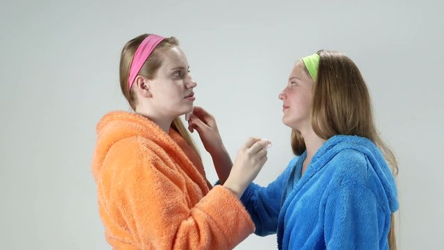 Teen skin care treatment to keep skin clean and clear teenage girls in bathrobes removing facial cream masks