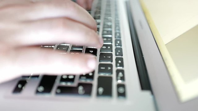 Footage of man writing on keyboard
