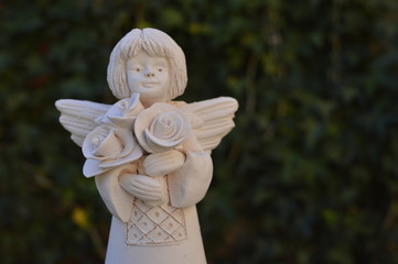 Smiling, white angel with bouquet of roses
