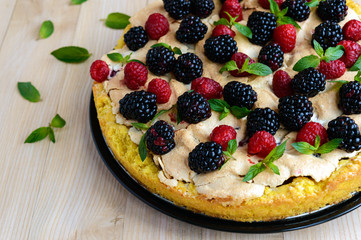 Pie (Tart) with fresh blackberries and raspberries, air meringue, decorative mint. Close up. The top view