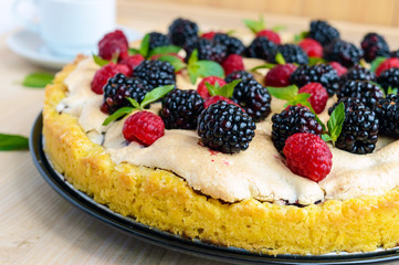Pie (Tart) with fresh blackberries and raspberries, air meringue, decorative mint. Close up