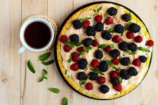 Pie (Tart) with fresh blackberries and raspberries, air meringue, decorative mint and cup of tea