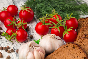 Still life of  tomatoes, black bread, garlic, fennel, bayberry p