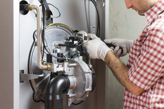 plumber repairing a condensing boiler in the boiler room