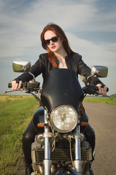 Biker girl in a leather jacket on a motorcycle © Demian
