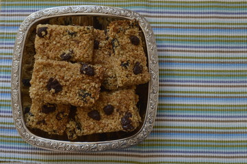 Flapjack - delicious bar with oatmeal, honey and dried fruit on silver platter
