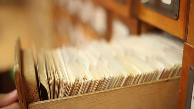 man finding needful information in catalog in a library, close up