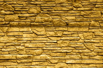 Photo sur Plexiglas Pierres Gold stone brick wall detailed contrast texture background