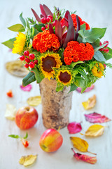 Obraz premium Autumn bouquet of flowers with apples and leaves . Autumn still life.