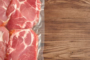 Photo sur Plexiglas Viande Vacuum packed meat displayed on a wooden background