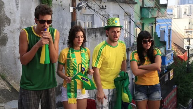 Four Brazilian football fans stand outside and cheer for their team