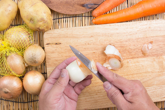 Chef peeling the onion for cooking