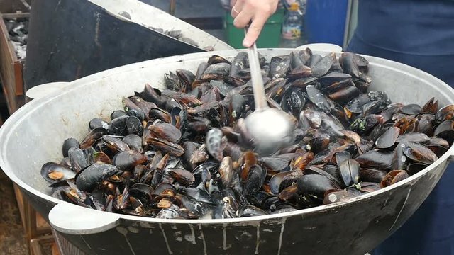 Chef cooking mussels on the street, slow motion