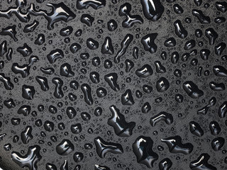 Abstract drops of water on black leather texture