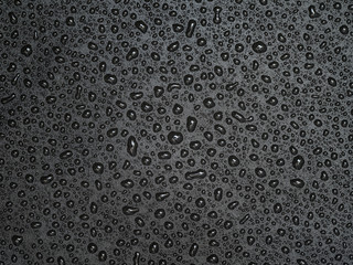 Abstract drops of water on black leather texture