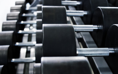 Naklejka na ściany i meble Dumbbells in the gym for classes bodybuilding for men, fitness and approach to iron weight.