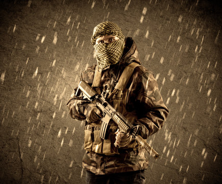 Dangerous heavily armed terrorist soldier with mask on grungy ra