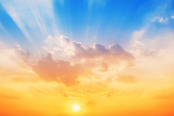 Obraz premium Zachód słońca na tle nieba, niebo zmieni kolory z niebieskiego na pomarańczowy.