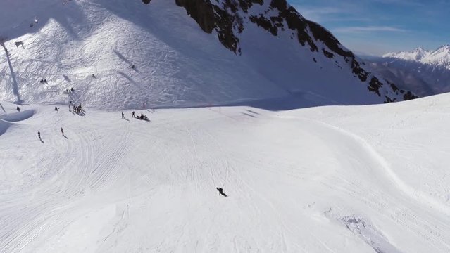 Quadrocopter shoot snowboarder jump from springboard. Snowy mountain. Sun. Speed. Extreme sport.