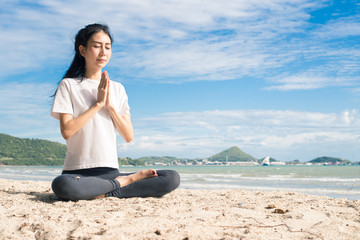 Fototapeta premium young woman practicing yoga on the beach