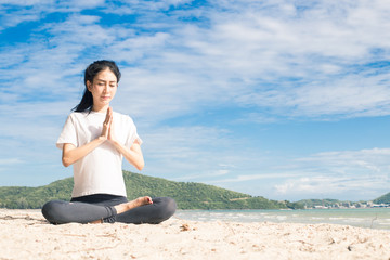 Naklejka na ściany i meble young woman practicing yoga on the beach