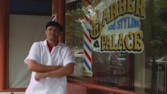Portrait of barber in front of store