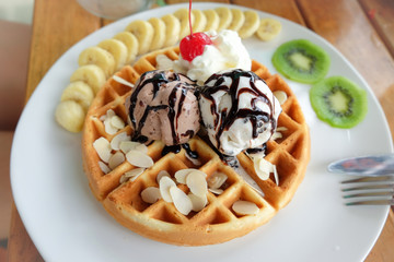 Baking waffle and topping by ice cream, almonds and fruits