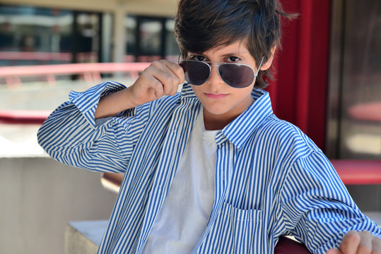 Schoolboy in professional look with sun glasses in a mall