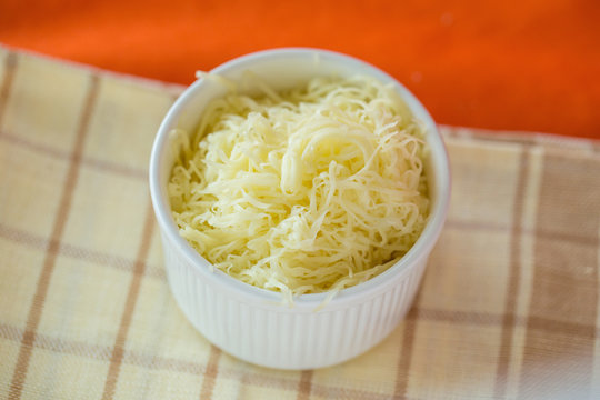 Grated cheese in a white bowl