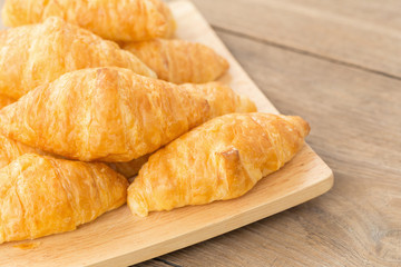 fresh croissants on wooden table