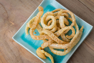 Pork rind junk food snack on a wooden table