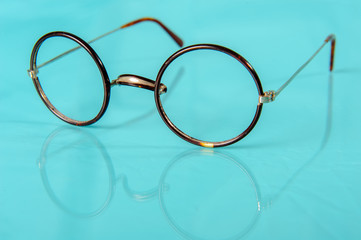 Fototapeta na wymiar old round glasses on reflective ground