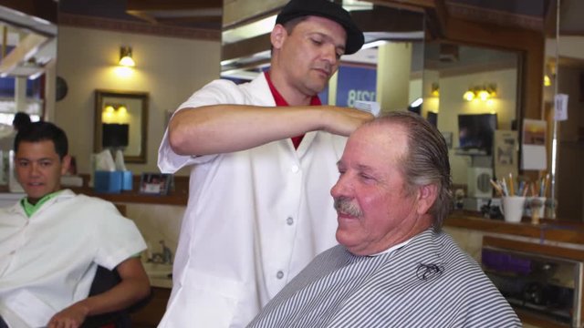 Elderly man in barber shop getting haircut