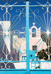 The view of blue gate and Orthodox Cathedral visible in the background  on Santorini island in Greece    