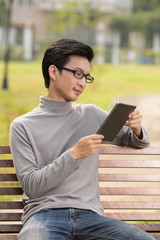 Man use tablet for relaxation at park