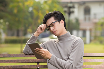 Fototapeta premium Man use tablet and thinking at park
