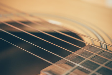 closeup picture of an acoustic guitar in a film tone, vintage style