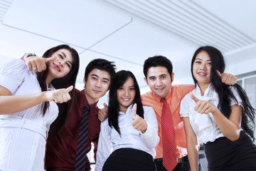 Business team showing OK sign in office