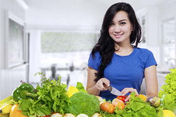 Female model prepares vegetables at home