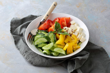 Tomatoes, cucumber and paprika salad in white bowl