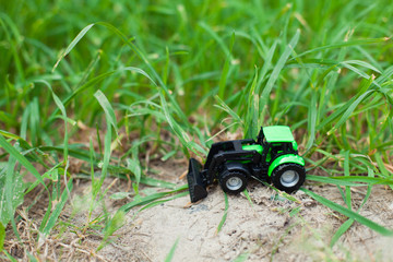 children's toy tractor on a green field