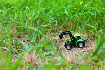 children's toy tractor on a green field