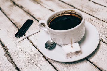 Cup of coffee with cigarette on the wooden table
