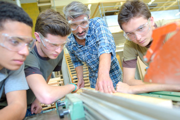 Teacher with three students,  using machine