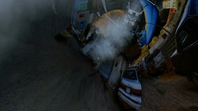 Helicopter penetrates the asphalt tunnel filled with smoke with rotating camera