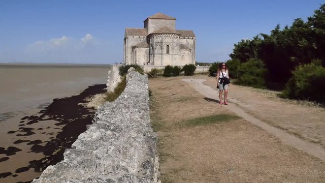 femme visitant l'&eacute;glise de Talmont sur gironde