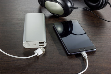 mobile phone and power bank battery on dark background